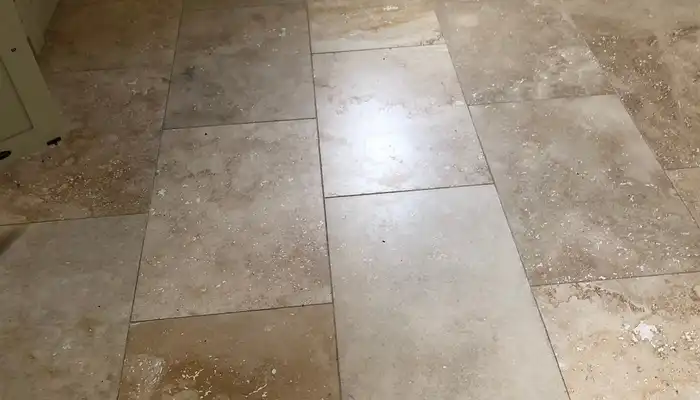 Close-up view of travertine floor showing pits, open holes, and filler repairs